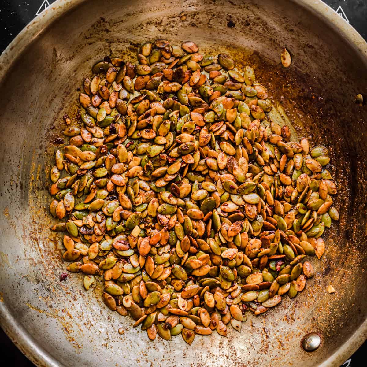 Seed sprinkle ingredients in a frying pan after being cooked.