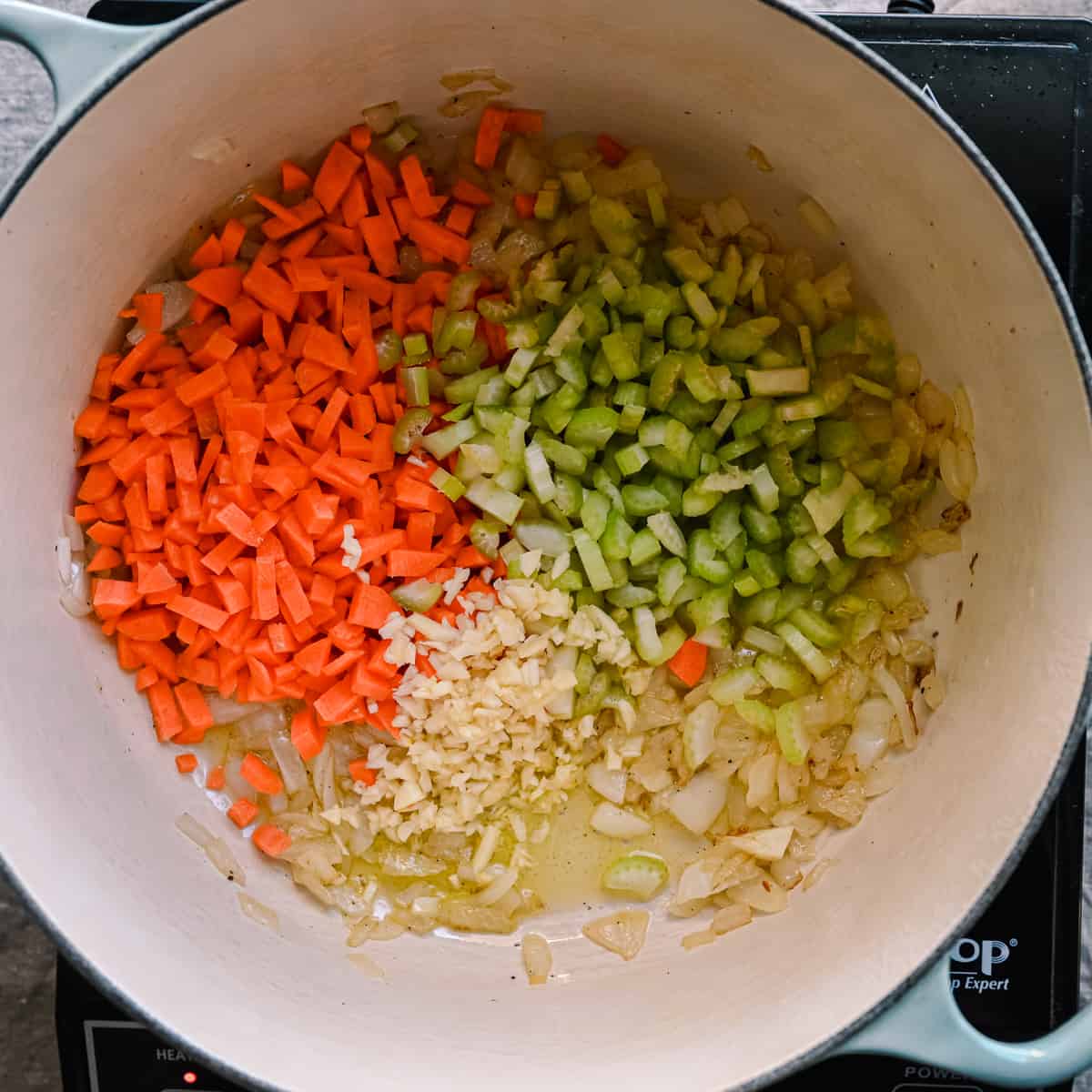 onions, garlic, carrots and celery sauteing in olive oil in dutch oven