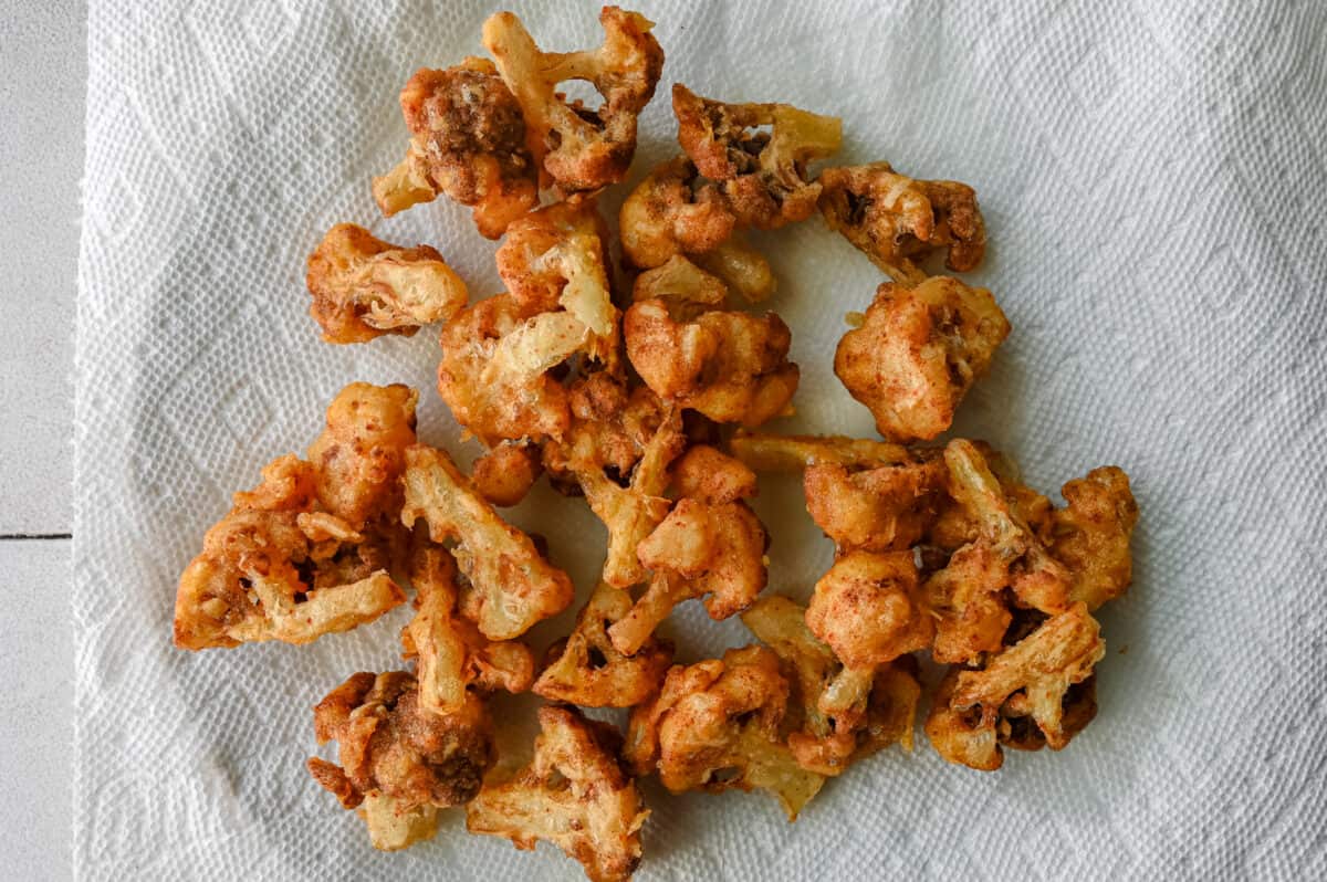 fried cauliflower florets on a paper towel