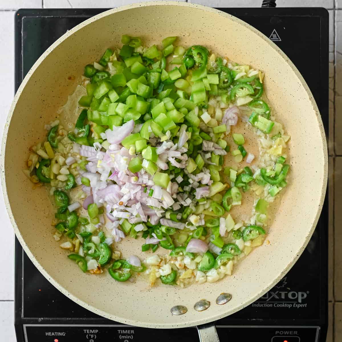 scallions, shallots, green peppers, garlic and ginger frying in saute pan