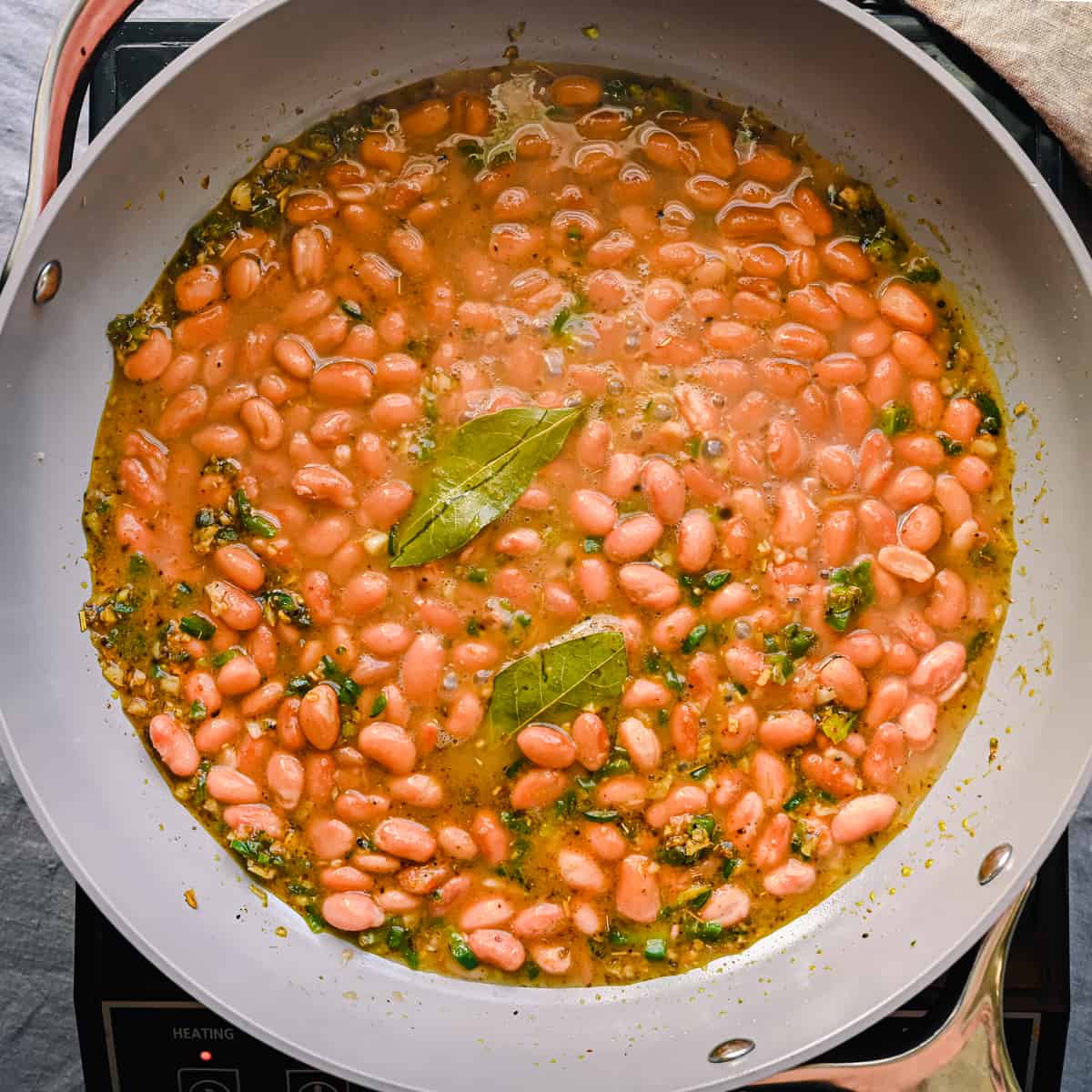 saucy pinto beans cooking in frying pan