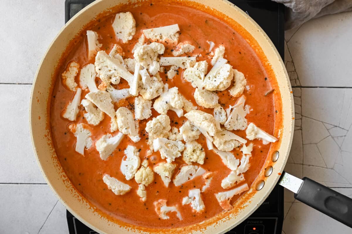 cauliflower florets in an Indian tomato curry in a frying pan