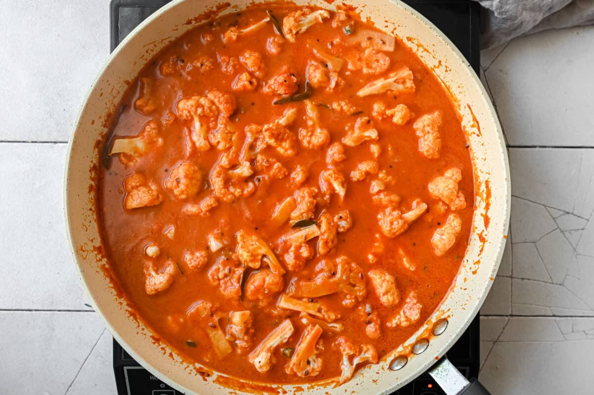 vegan cauliflower tomato curry in a frying pan