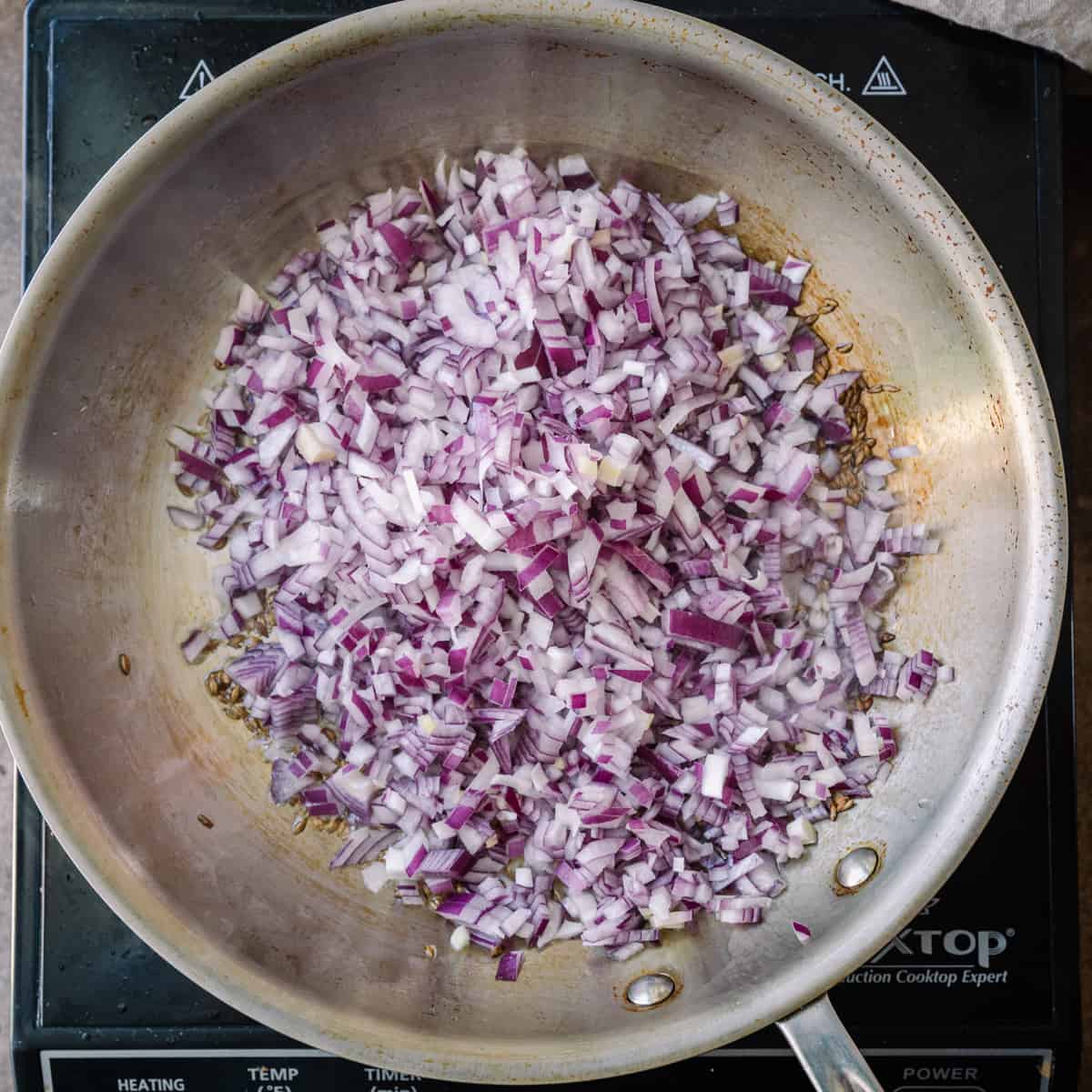 diced red onions in frying pan