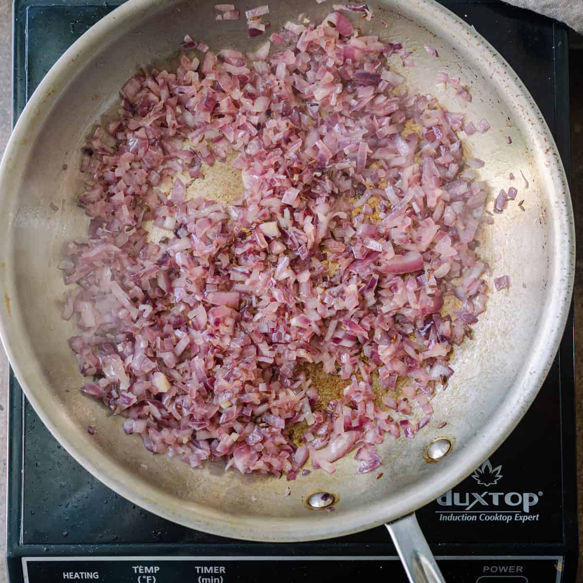 sauteing diced red onions in frying pan