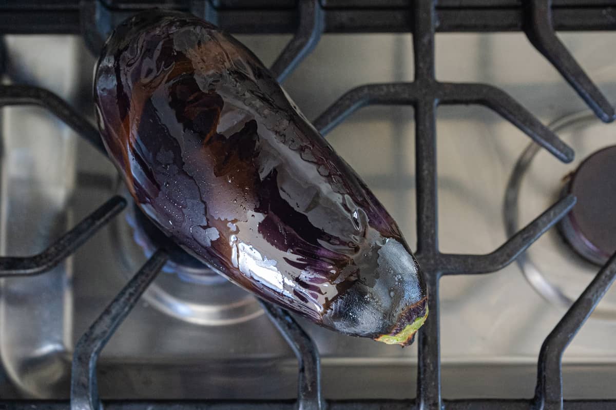 whole eggplant roasting on open gas flame for baingan bharta