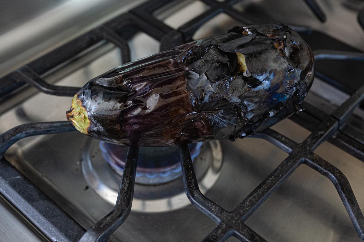 whole eggplant roasting on open gas flame for baingan bharta