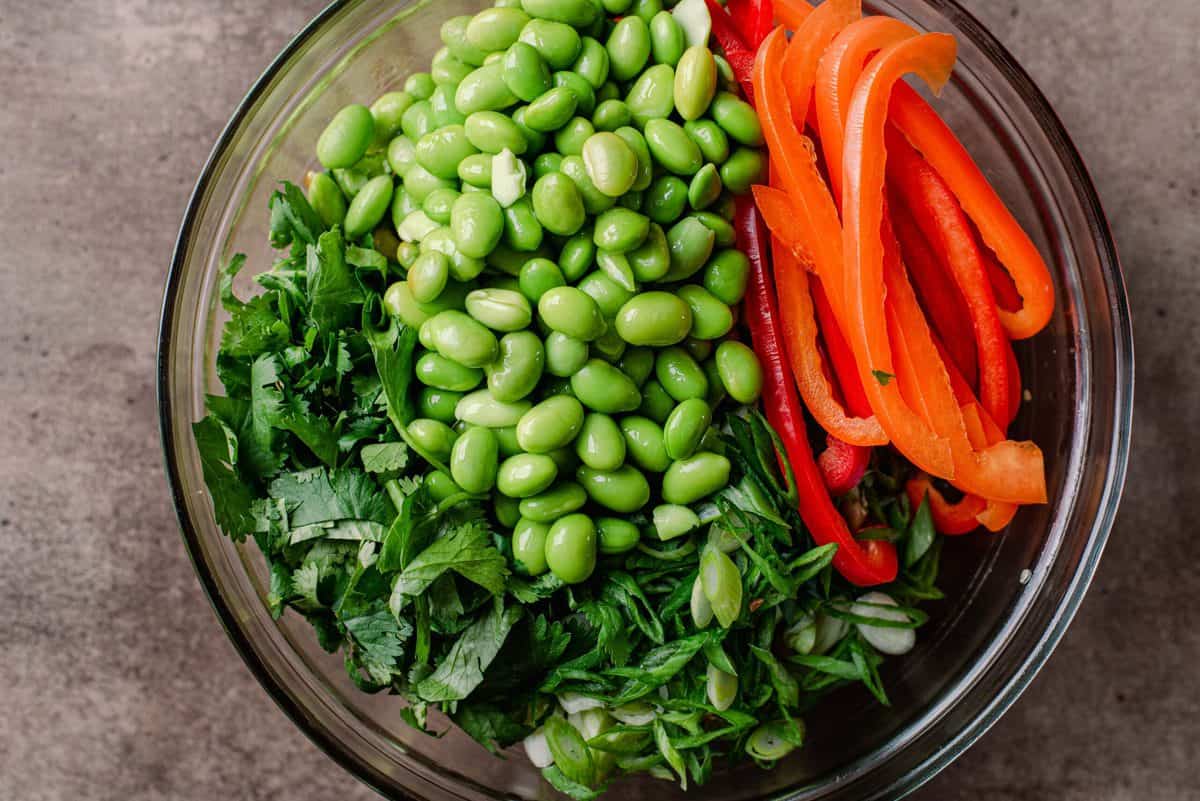 cilantro, edamame, and bell peppers in a glass bowl