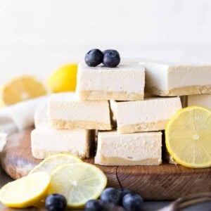Stack of lemon bars on a wooden cutting board.