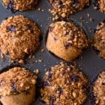 closeup of vegan blueberry muffins with walnut brown sugar crumble in muffin tin.