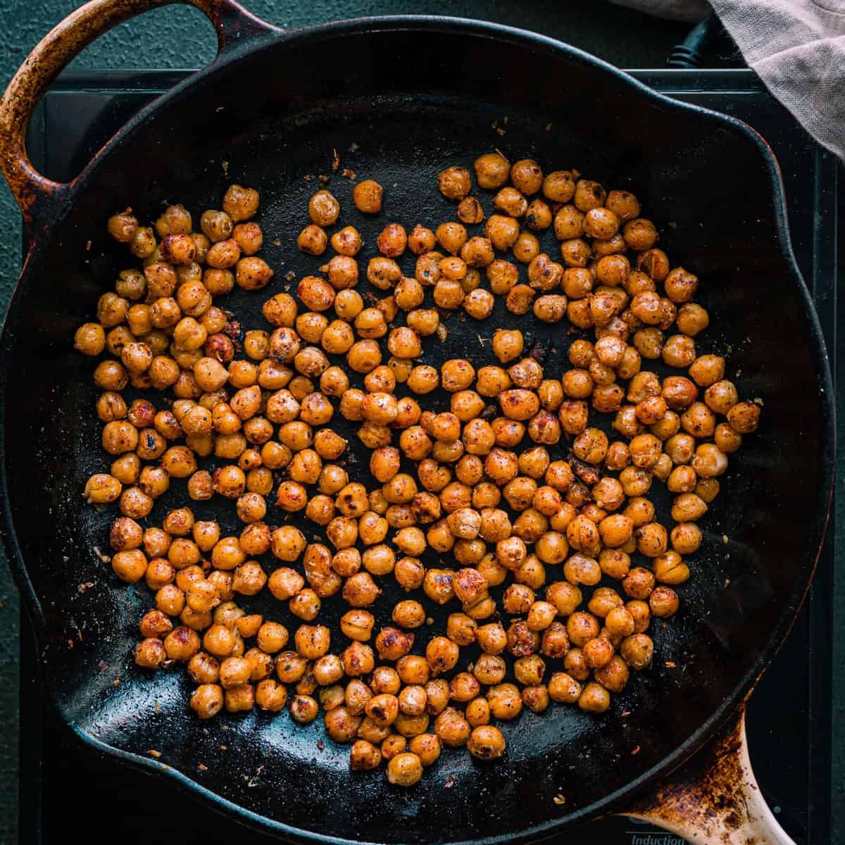 spiced chickpeas frying in a skillet