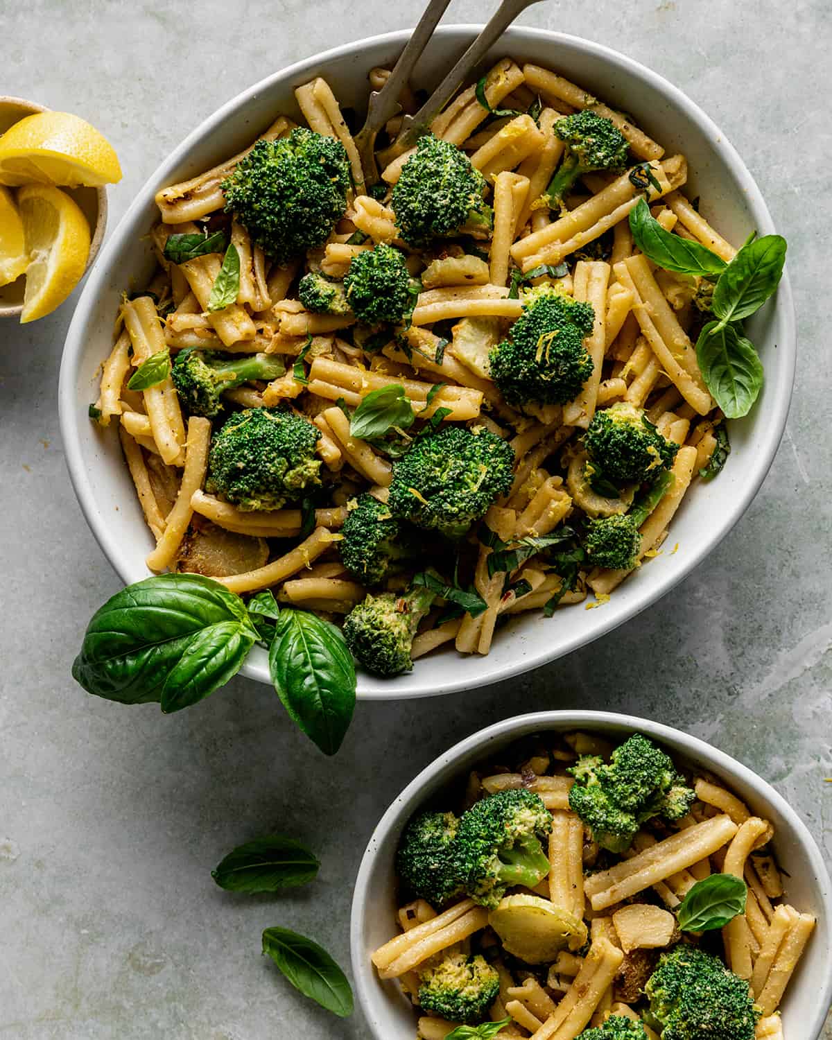 a bowl of tahini pasta and broccoli with a small bowl of pasta below it.