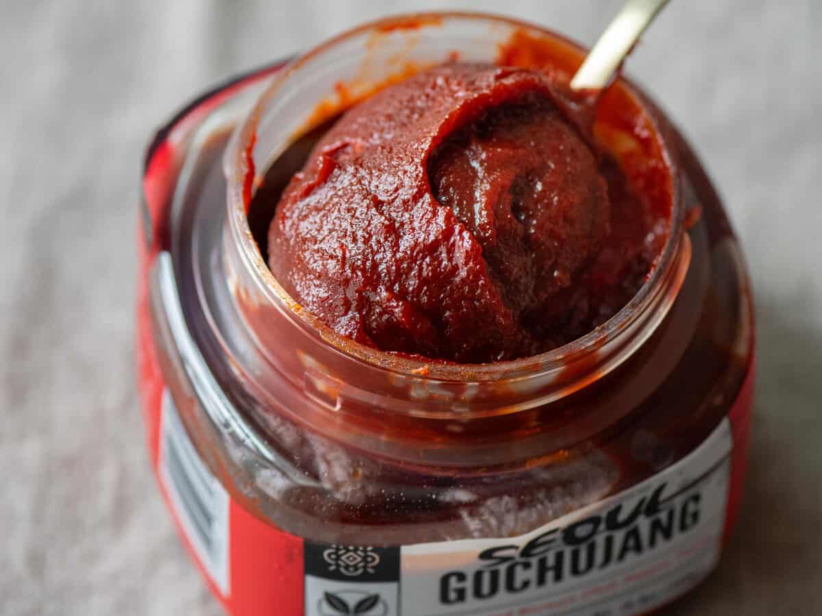 scooping gochujang out of a tub. 