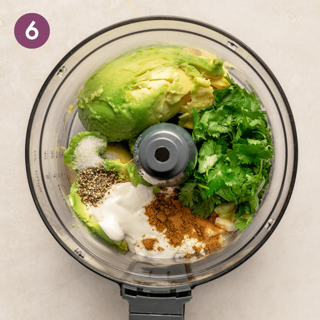 Avocado crema ingredients in a food processor before being blended.