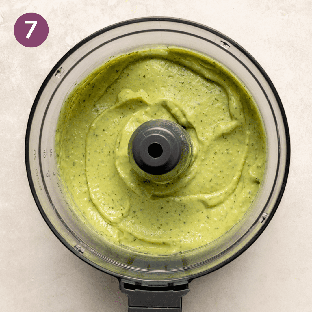 Creamy avocado crema in a food processor after being blended.