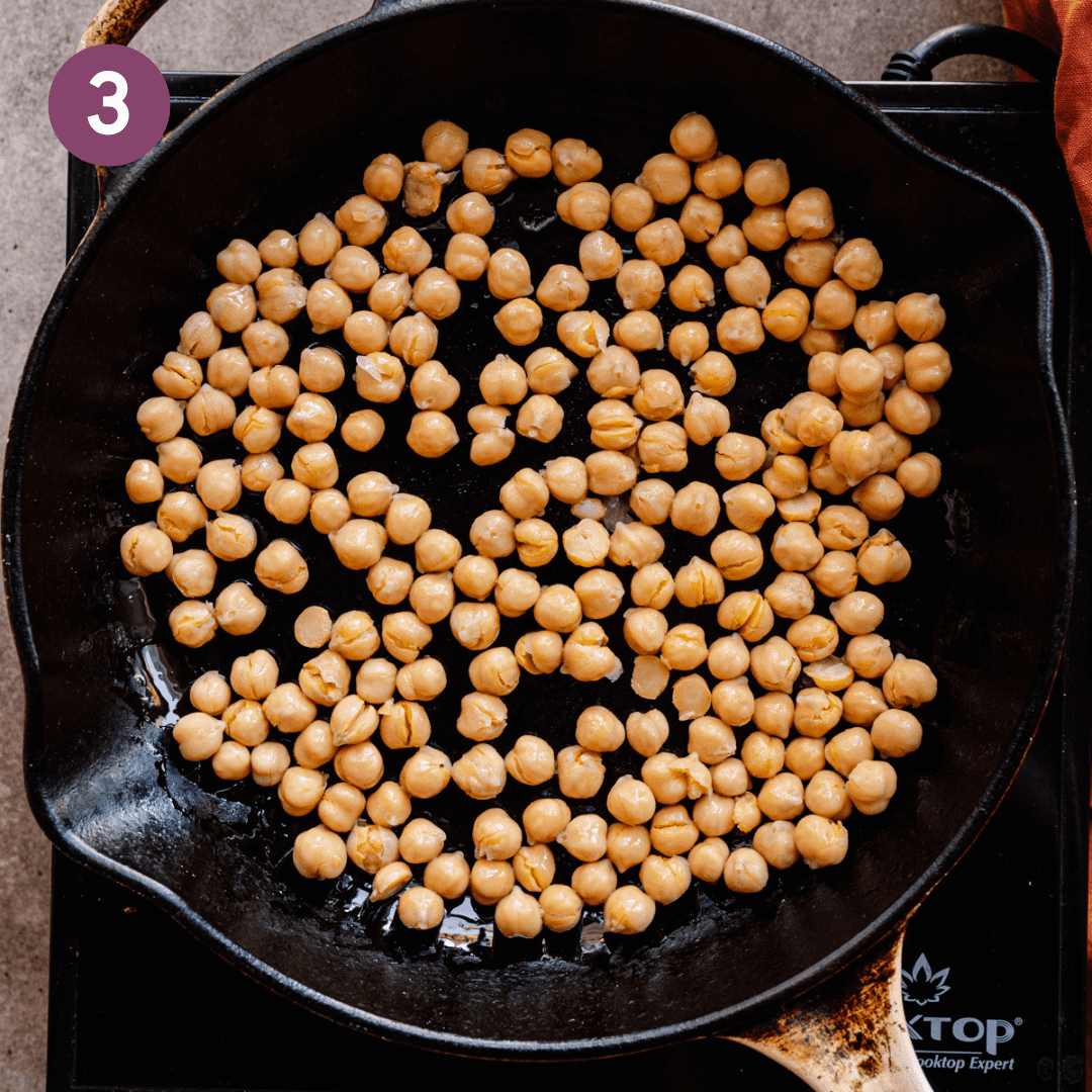 Chickpeas in a large pan with oil.