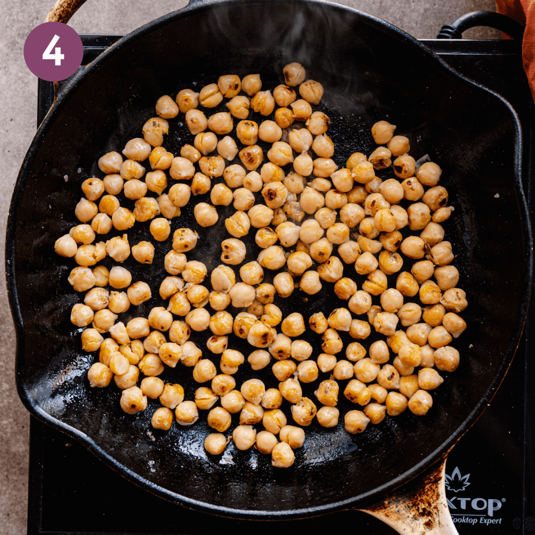 Blistered chickpeas in a large pan.