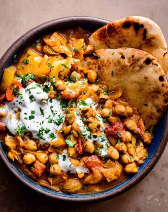 bowl of braised indian chickpea stew with naan.