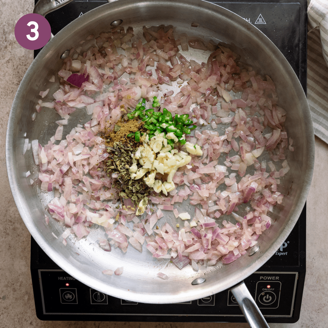 Garlic, chipotle chile, cumin and oregano added to onions in pan.