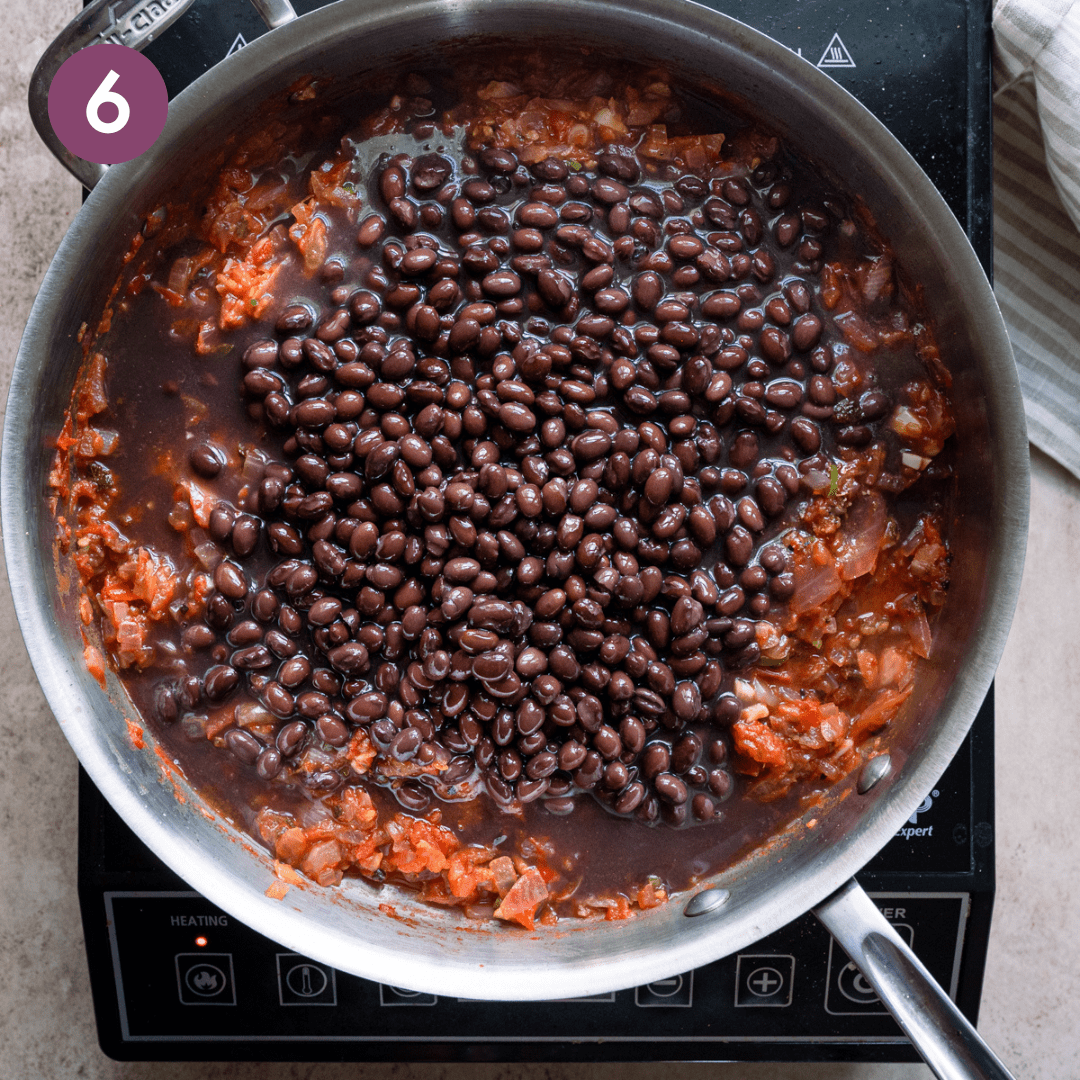 Black beans and their liquid added to tomato mixture.