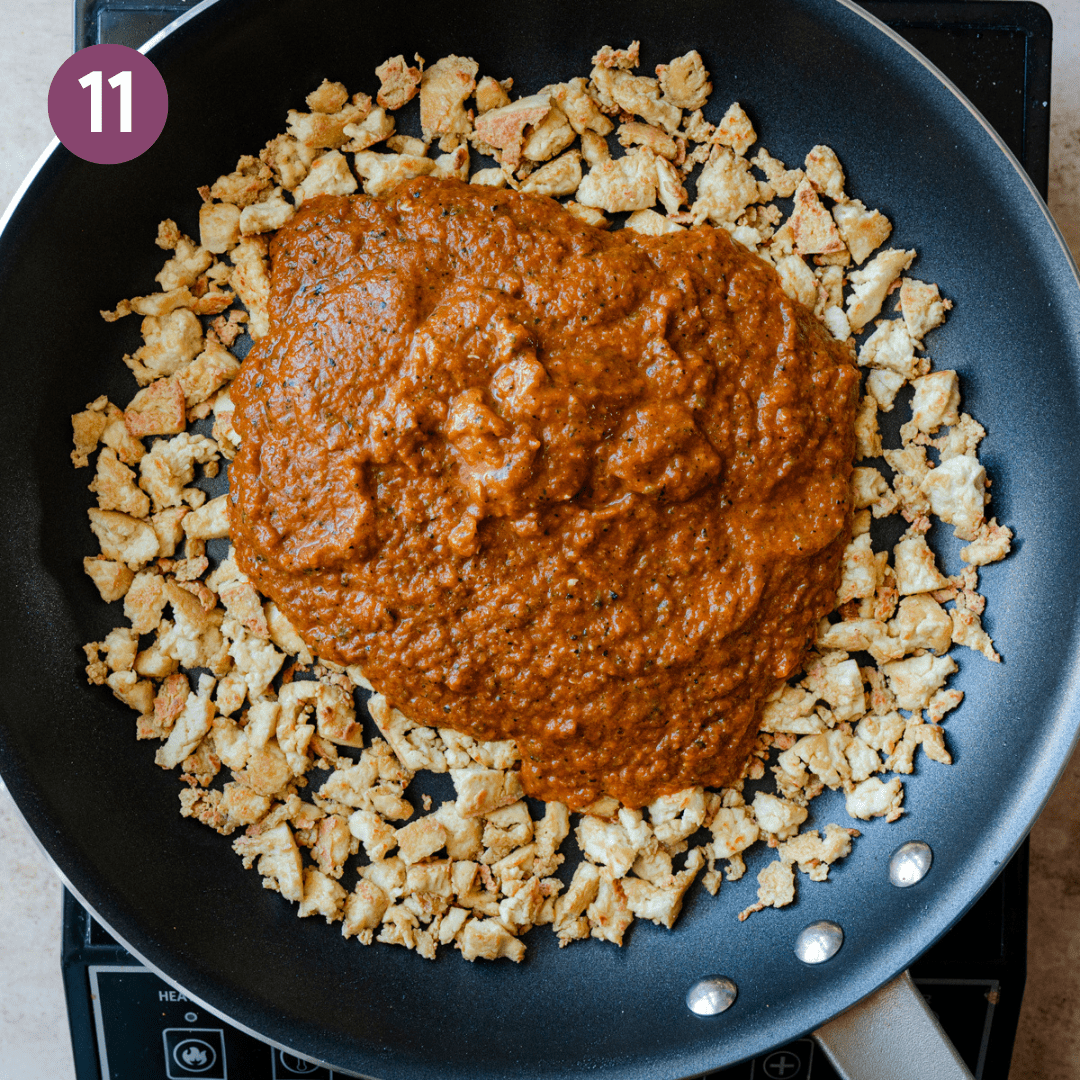 Blended chipotle-tomato-onion-poblano pepper sauce on top of browned crumbled tofu in a frying pan. 