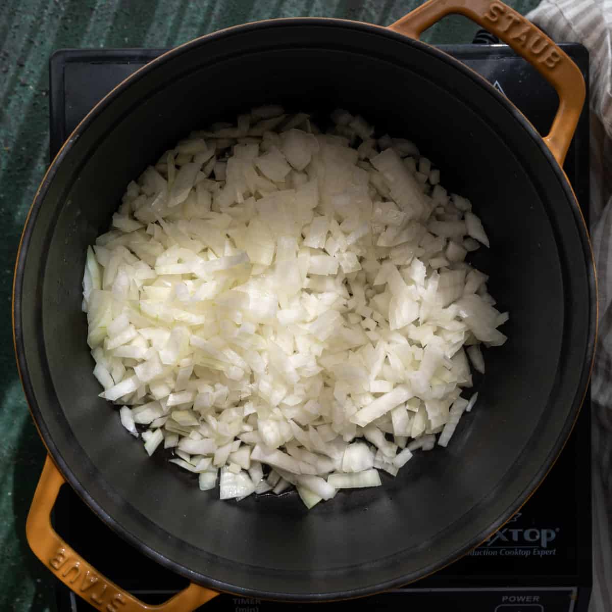 chopped onions being sauted in a dutch oven.