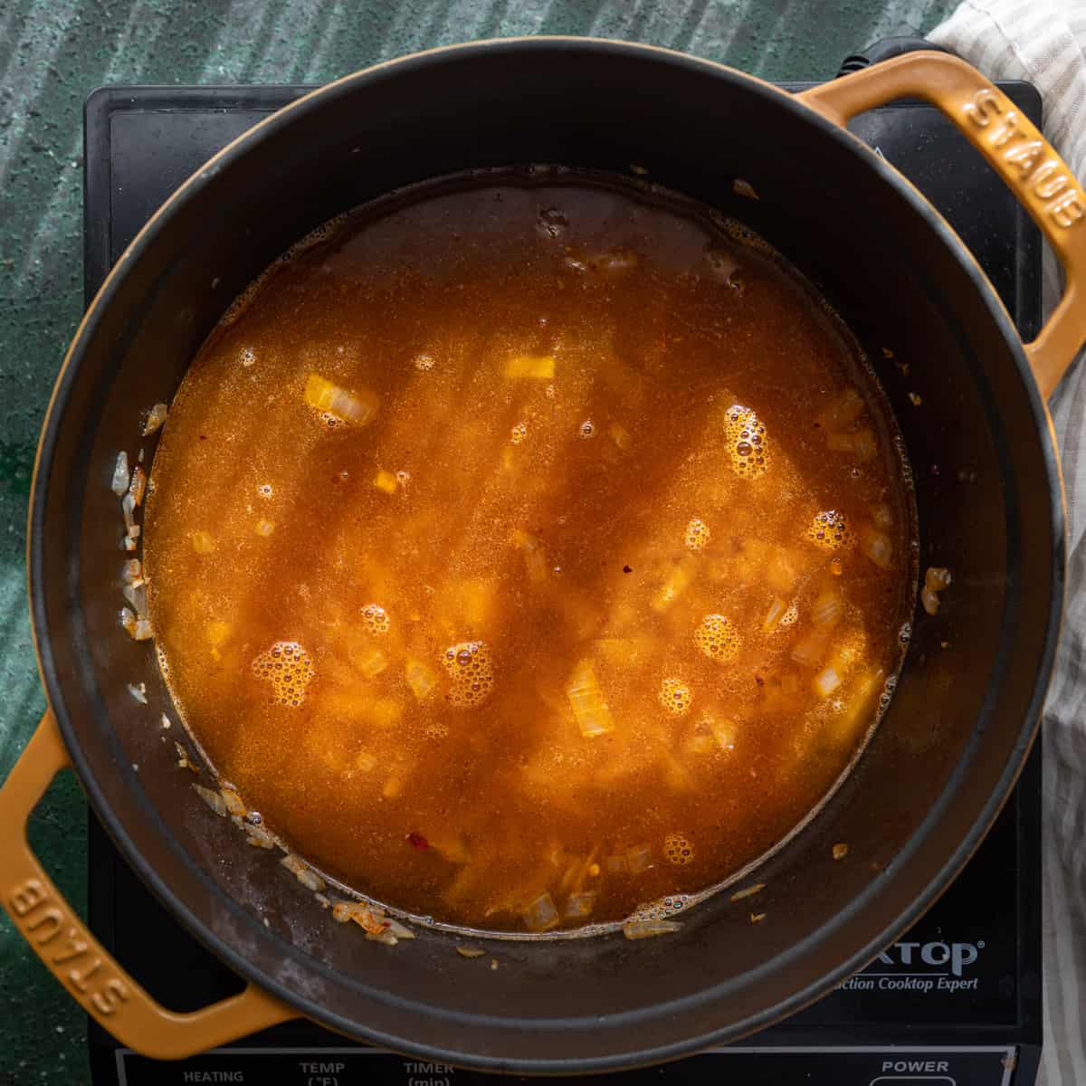 vegetable broth poured into onion and spice mixture in a dutch oven. 