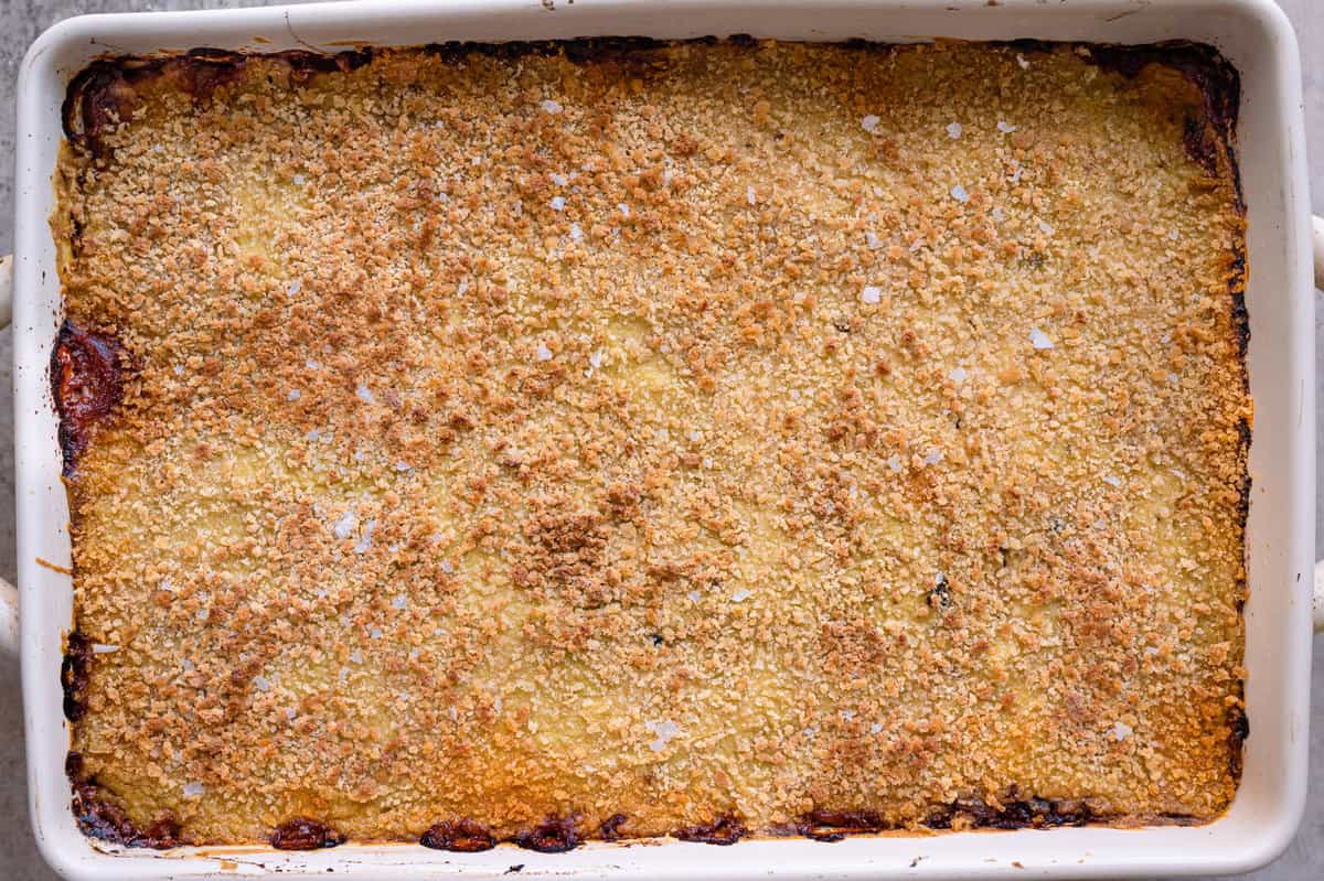 crispy golden brown topped vegan moussaka in a casserole pan. 