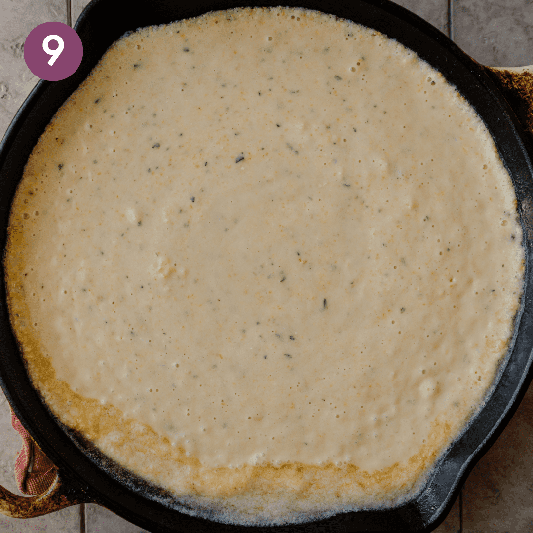 a cast iron skillet filled with vegan cornbread batter about to be baked.