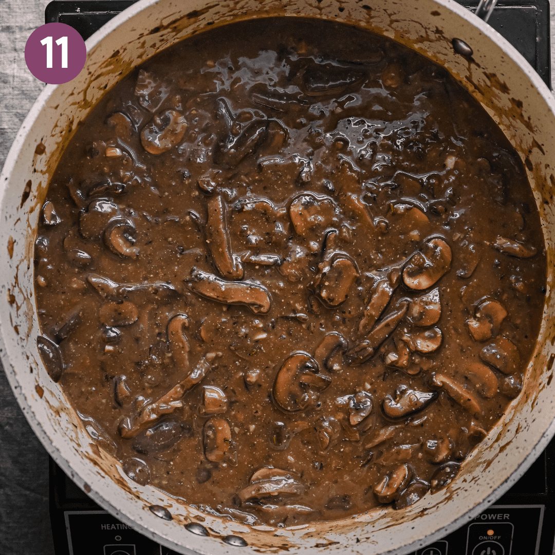 a thick vegan gravy with mushrooms in a ceramic saute pan.