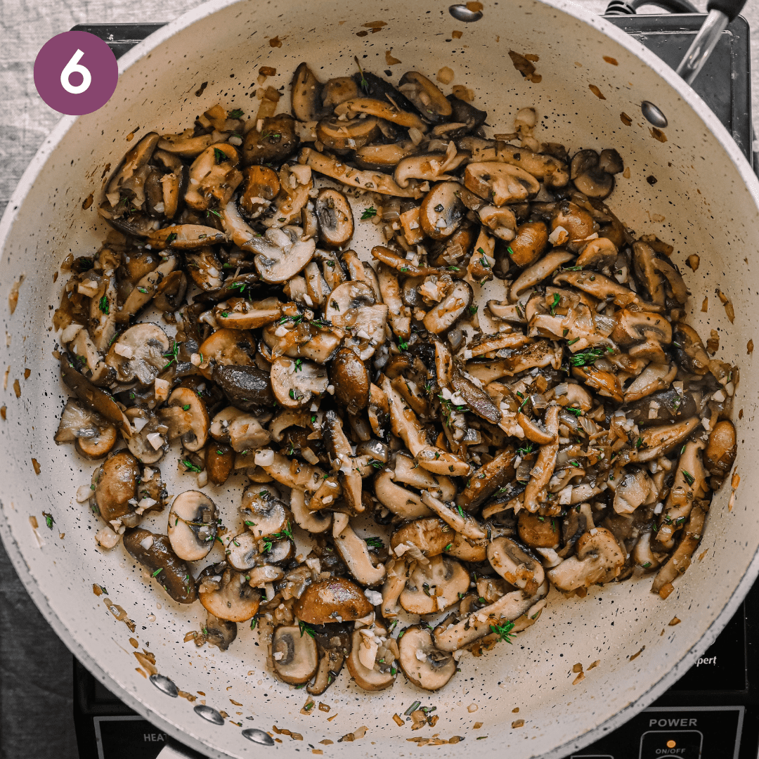 golden brown mushrooms sauteed with garlic and herbs in a ceramic saute pan.
