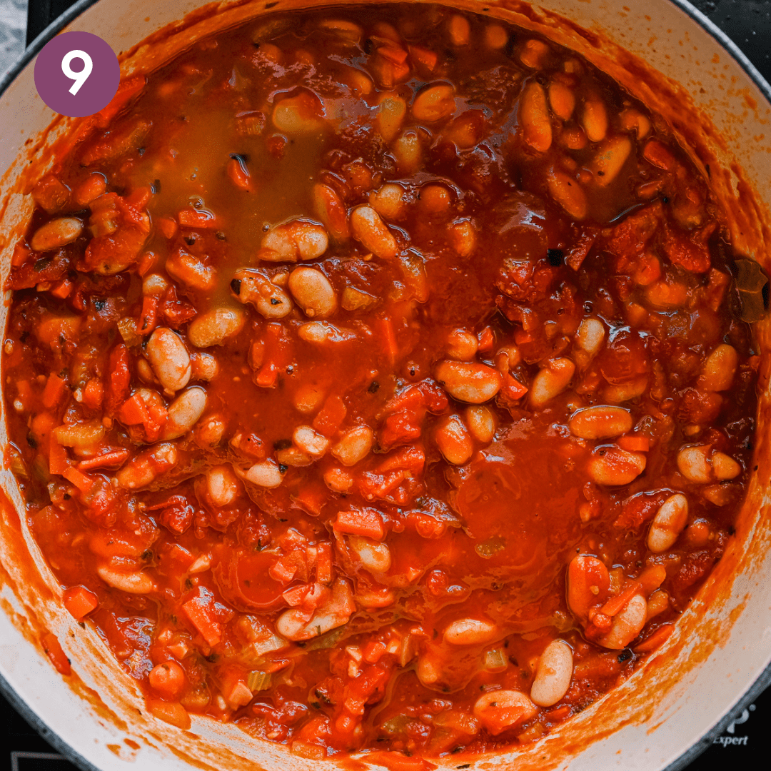 thick and rich tuscan stewed beans with tomatoes in a dutch oven.