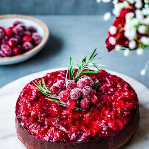 Baked vegan cheesecake on a marble platter on grey table.