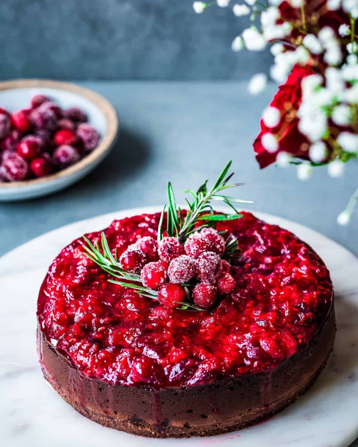 Baked vegan cheesecake on a marble platter on grey table.