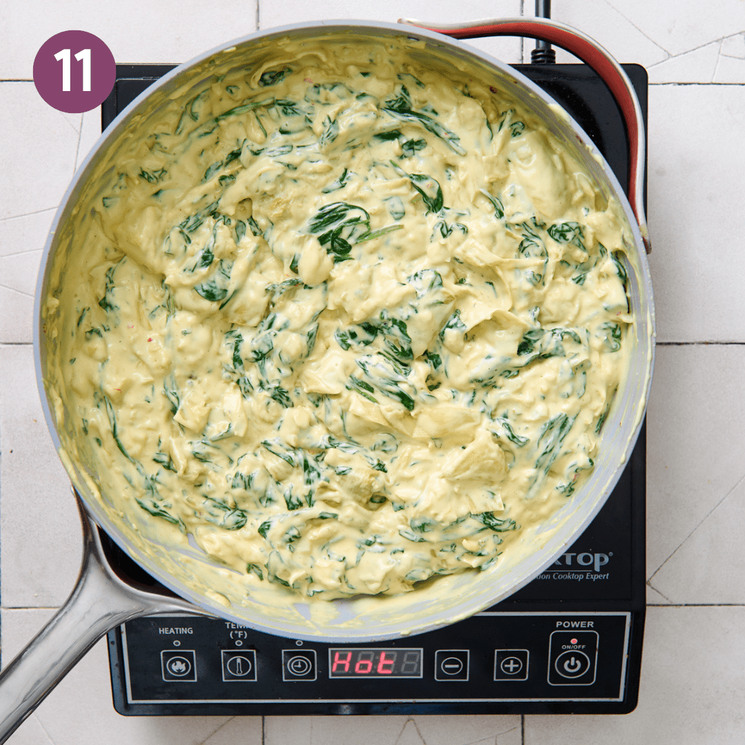 Heated and thickened spinach artichoke dip in pan.