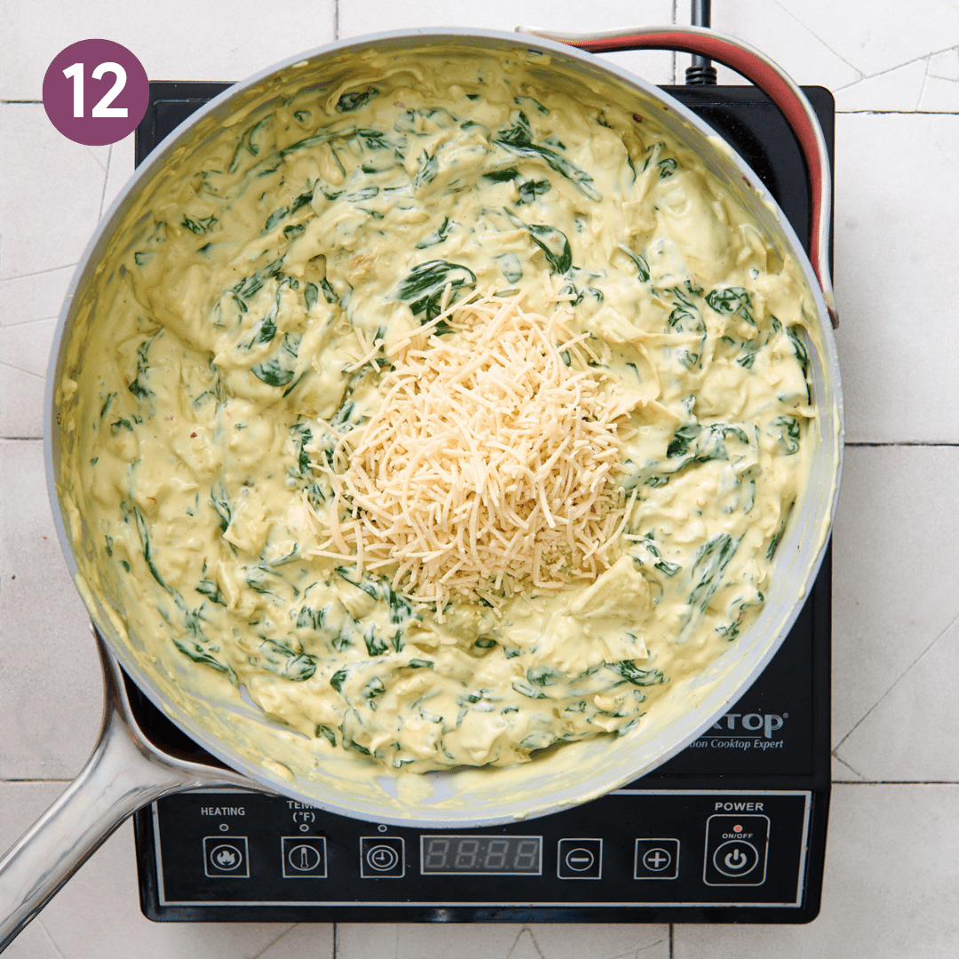 Vegan parmesan cheese on top of artichoke dip before being mixed in.