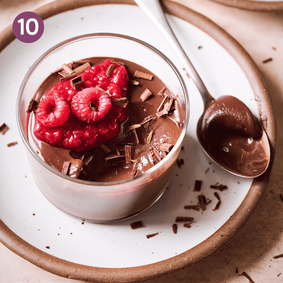 Finished ramekin of chocolate mousse topped with raspberry and raspberry compote.