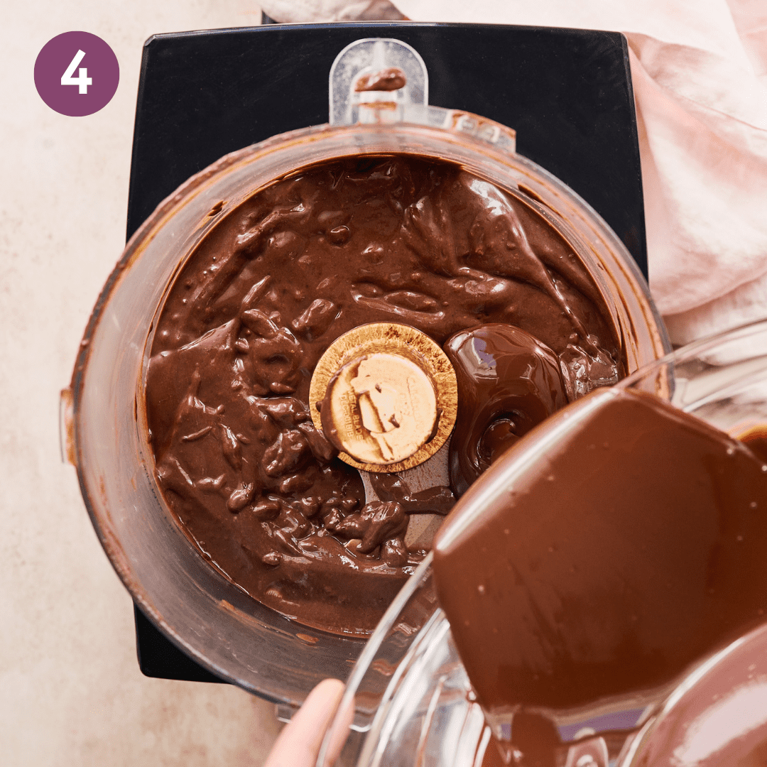 Melted chocolate mixture being poured into food processor with rest of ingredients.