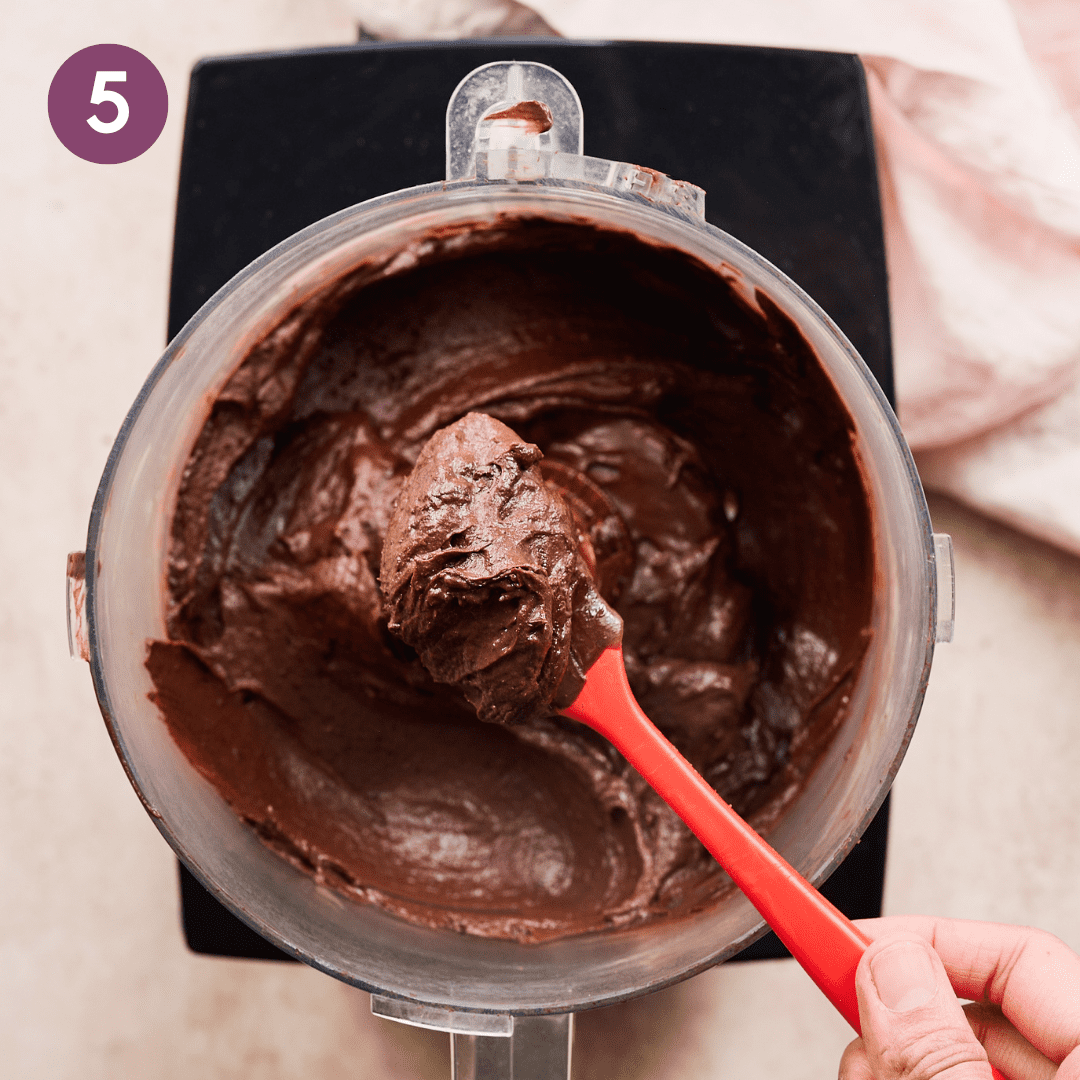 Person scooping mousse from food processor with silicone spatula.