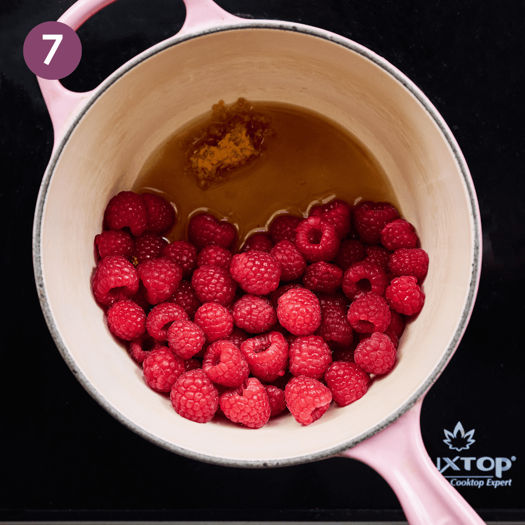 Raspberry compote ingredients in saucepan on stove.