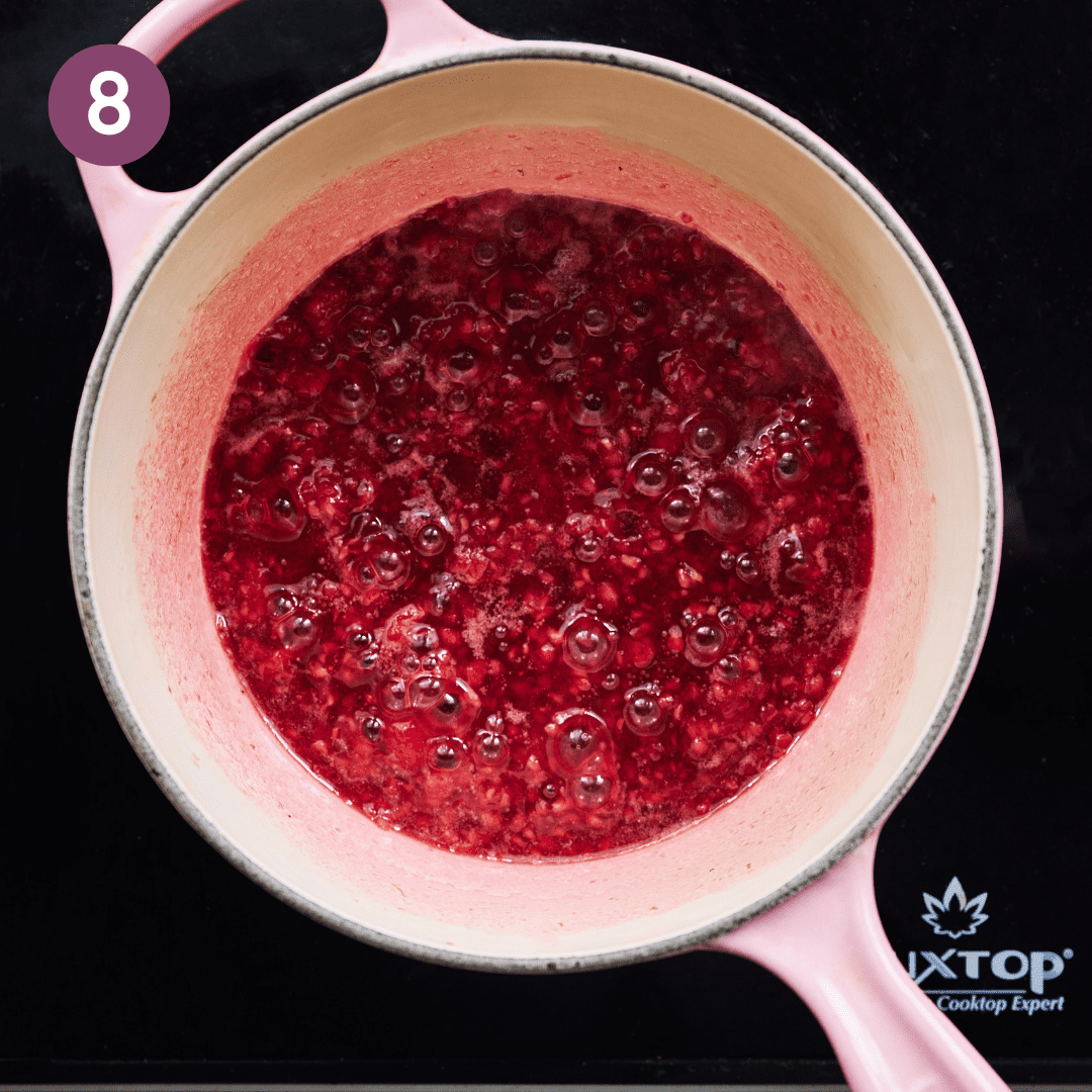 Raspberry compote becoming jammy in the stove over heat.