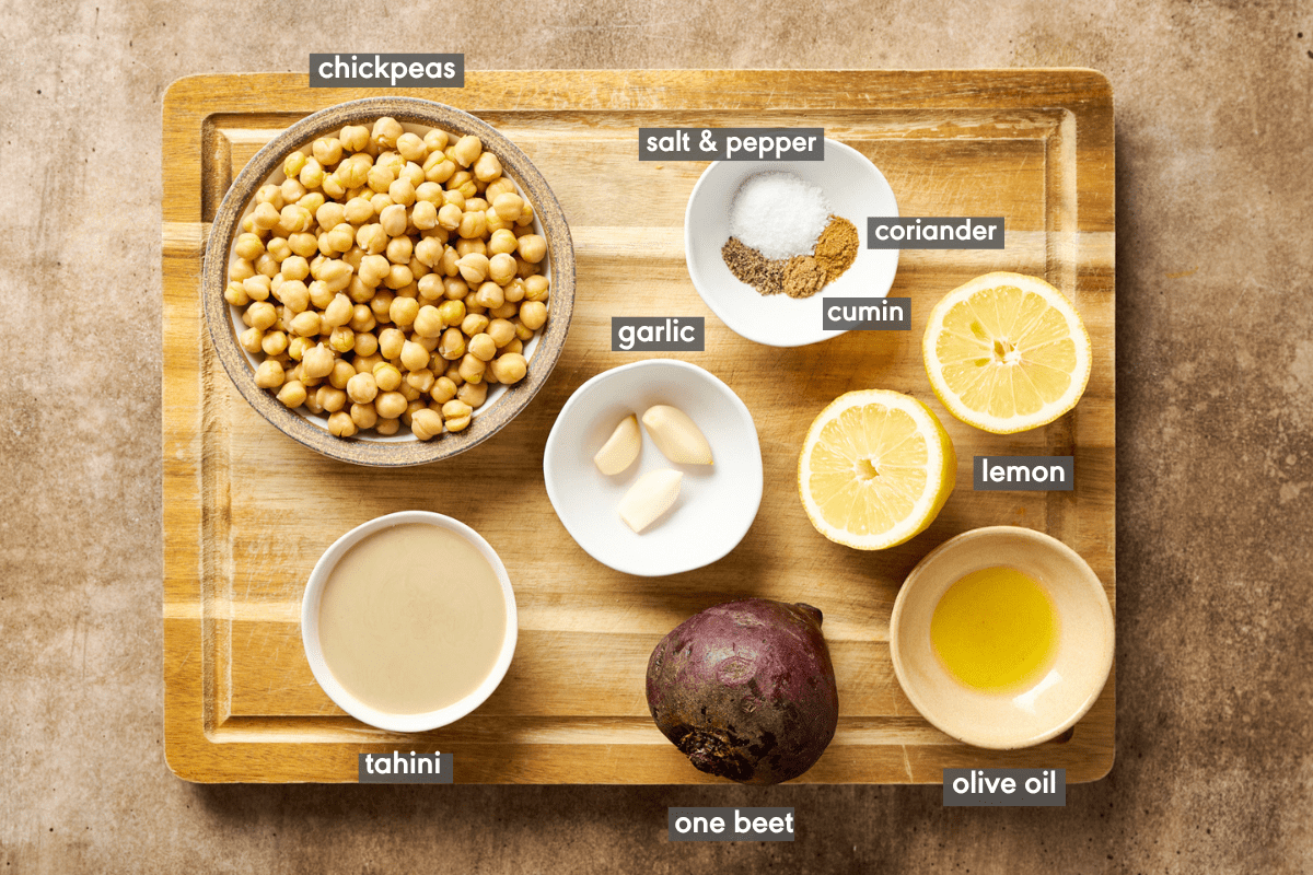 Labeled beet hummus ingredients in various small bowls on a cutting board.