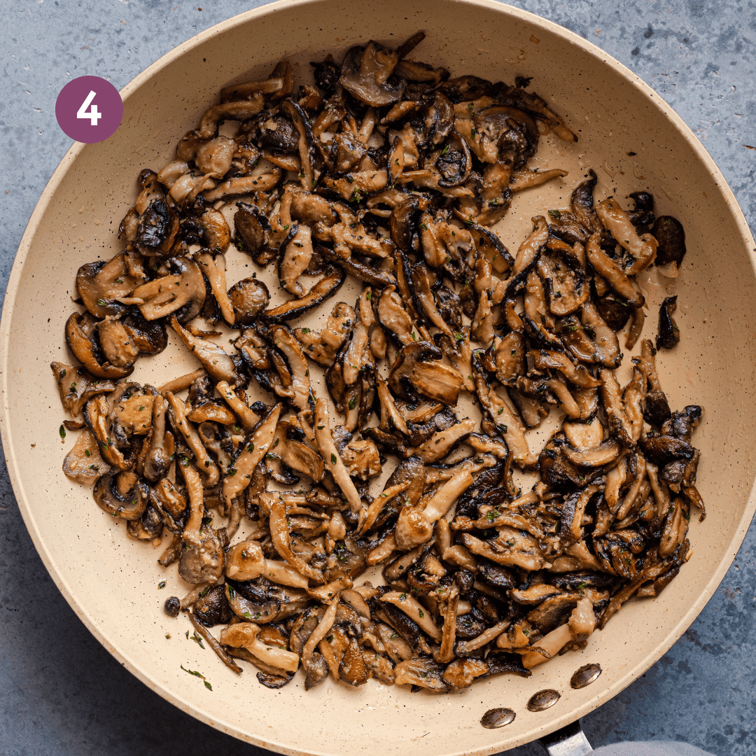 golden brown sauteed mushrooms with herbs and garlic in a saute pan. 