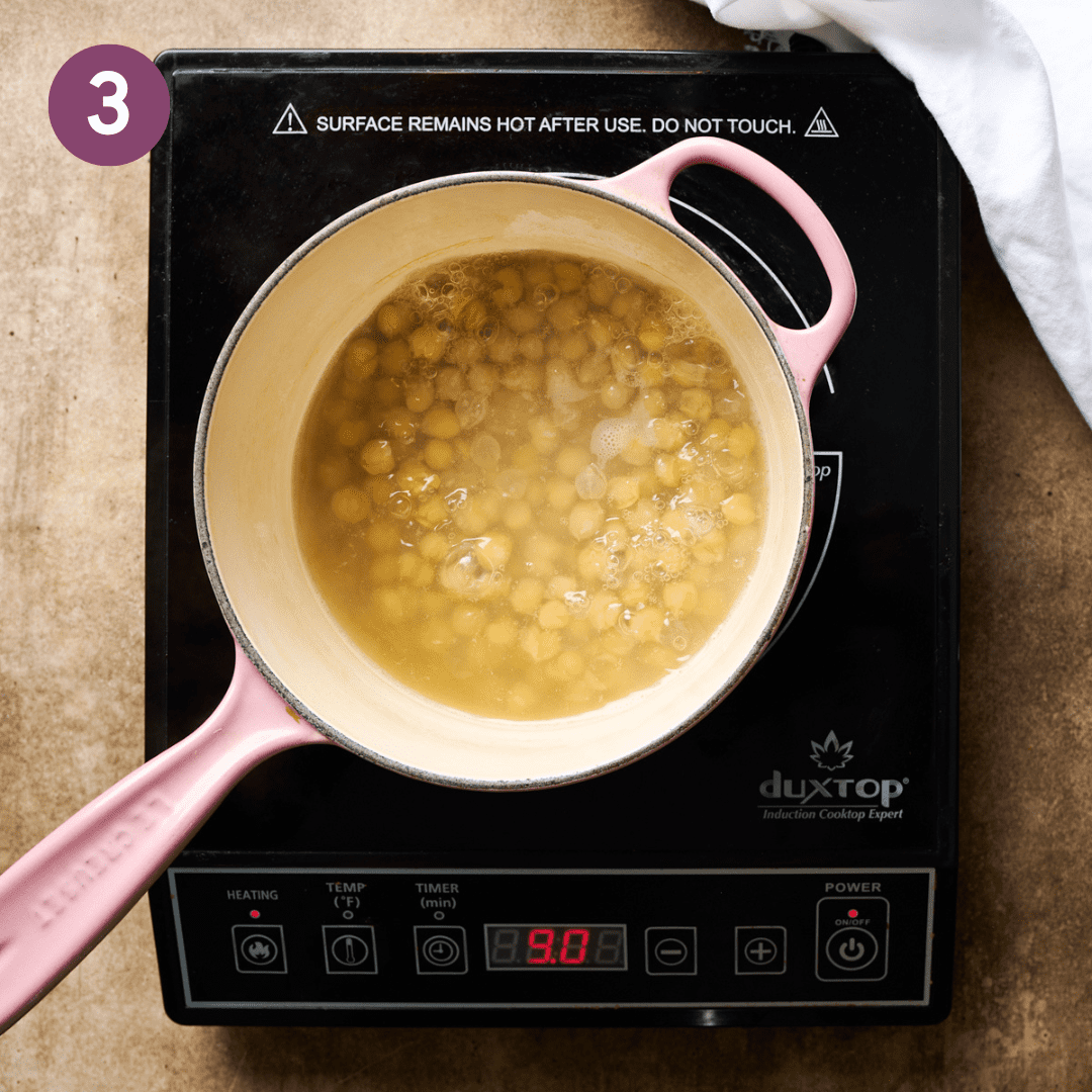 Chickpeas and water in saucepan after being boiled.