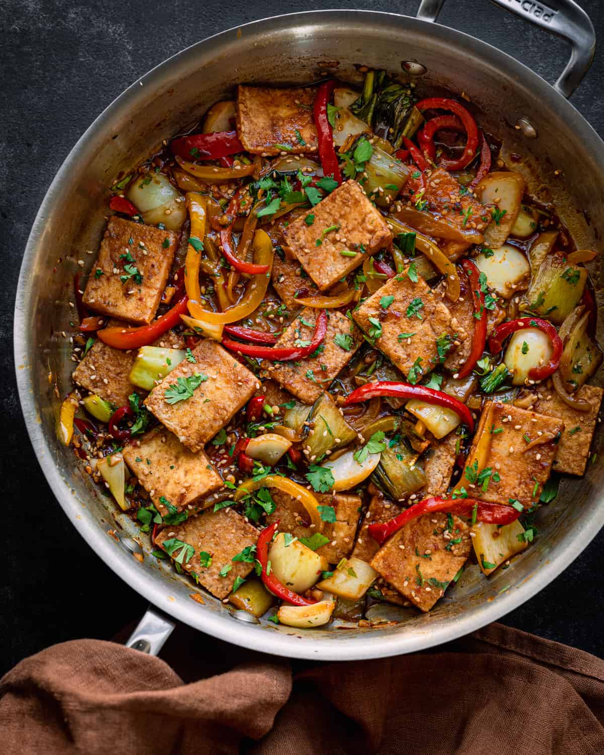 Finished tofu and peppers in a deep silver skillet.