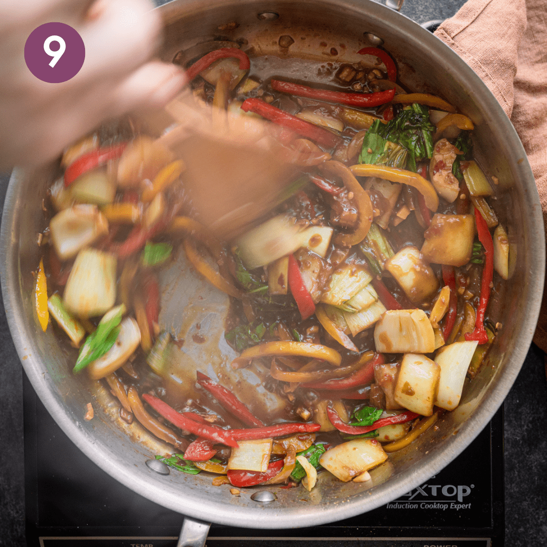 Person stirring cornstarch mixture into vegetables.