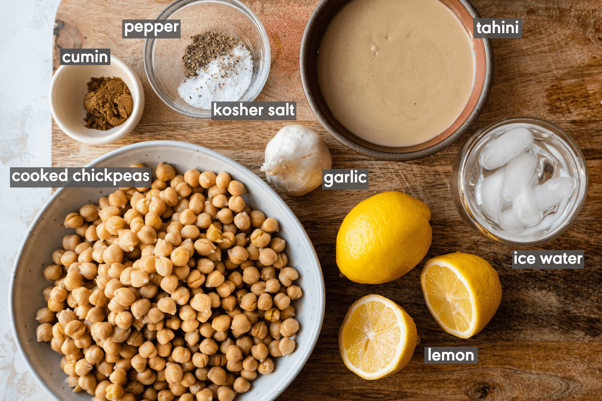 Labeled hummus ingredients laid out on a wooden cutting board.