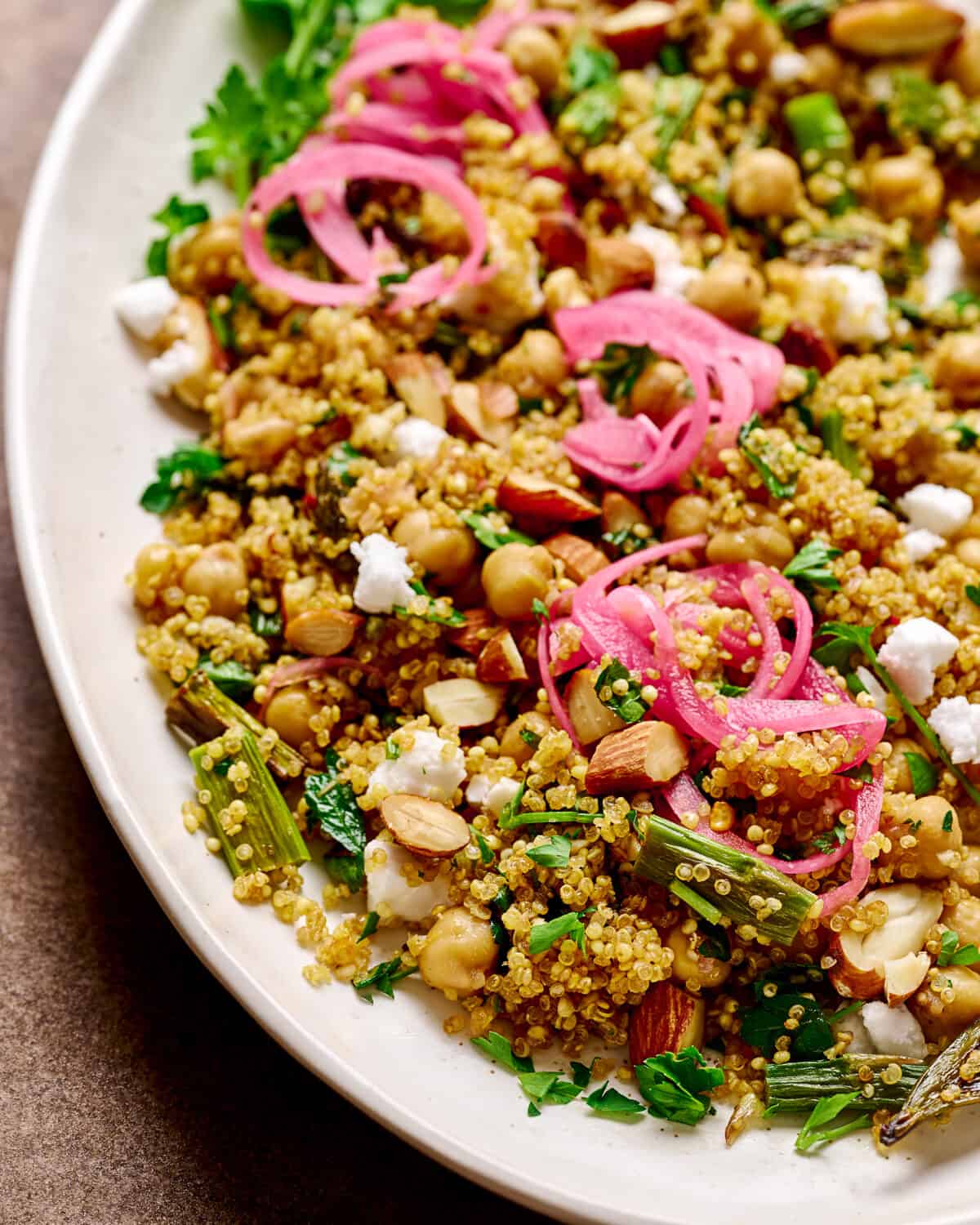 Close up photo of quinoa salad with pickled onion and vegan feta.