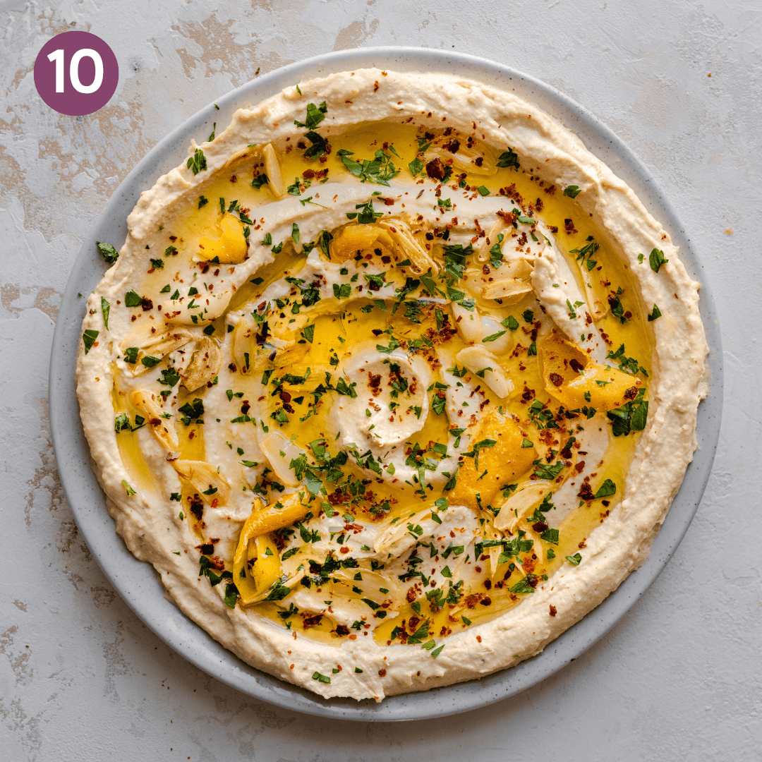 Finished hummus with olive oil, lemon garlic topping, parsley and paprika.