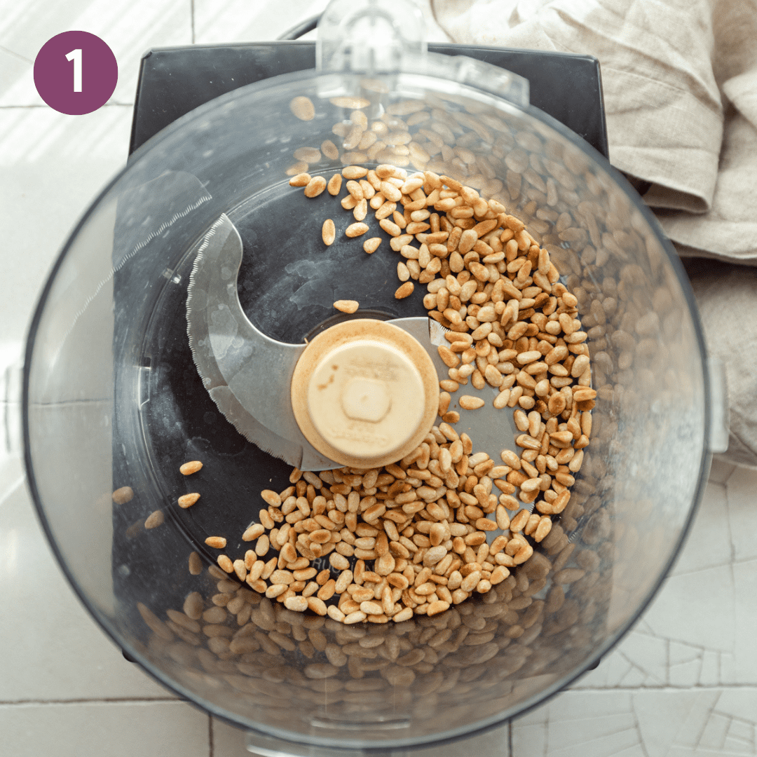 Toasted pine nuts in a food processor before being pulverized.